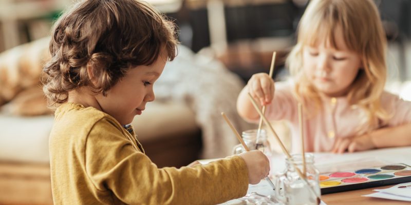 Close up of a brother and sister painting together